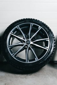 High-quality image of a modern alloy wheel and tire on a sleek white background.