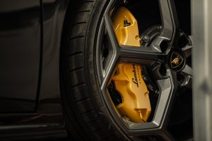 Detailed view of a luxury car wheel with a distinctive yellow brake caliper, showcasing automotive design.